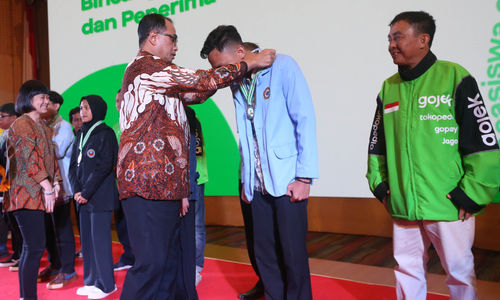 Menteri Perhubungan Republik Indonesia - Budi Karya Sumadi menyematkan medali kepada alumni penerima Beasiswa Gojek angkatan Pertama yang turut disaksikan oleh Direktur dan Presiden Unit Bisnis On-Demand Services Grup GoTo - Catherine Hindra Sutjahyo di Jakarta. 11 Desember 2023. Foto : Panji Asmoro/TrenAsia