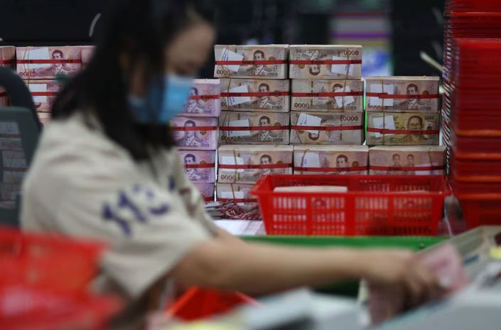 Seorang Pegawai Bank Mengumpulkan Uang Kertas Baht Thailand di Sebuah Kasikornbank di Bangkok, Thailand (Reuters/Athit Perawongmetha)