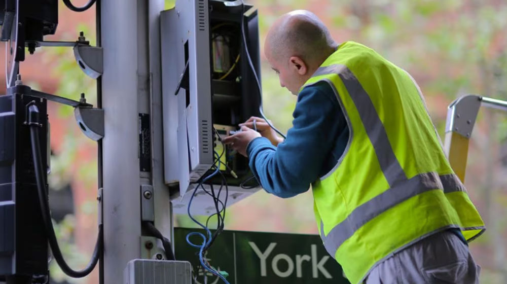 Seorang Pekerja Menyesuaikan Kabel Listrik Lampu Lalu Lintas di Pusat Kota Sydney, Australia