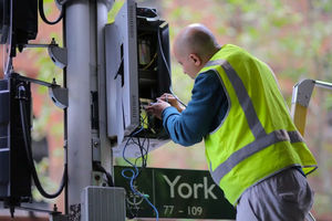 Seorang Pekerja Menyesuaikan Kabel Listrik Lampu Lalu Lintas di Pusat Kota Sydney, Australia