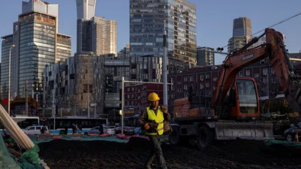 Seorang Pekerja Berjalan Melintasi Lokasi Konstruksi di Kawasan Pusat Bisnis