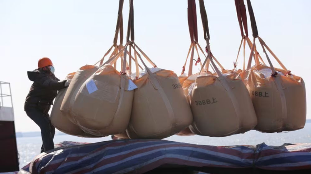 Seorang Pekerja yang Memakai Masker, Mengangkut Pupuk untuk Diekspor di Sebuah Pelabuhan di Nantong, Provinsi Jiangsu, China