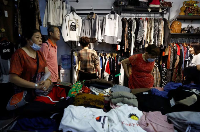 Pelanggan Berbelanja Pakaian di Sebuah Kios di dalam Pasar Grosir di Beijing, China (Reuters/Tingshu Wang)