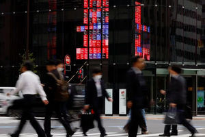 Pejalan Kaki Berjalan Melewati Papan Elektronik yang Menampilkan Harga Saham Berbagai Perusahaan, Di Sebuah Kawasan Bisnis Di Tokyo