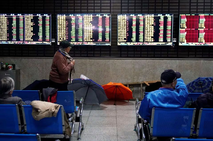 Investor melihat layar yang menampilkan informasi saham di sebuah rumah pialang di Shanghai, China (Reuters/Aly Song)