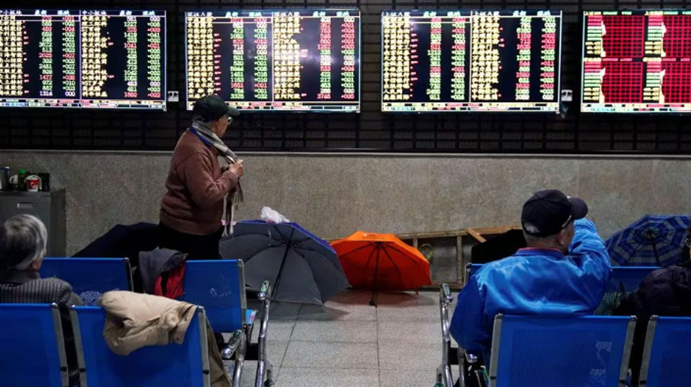 Investor melihat layar yang menampilkan informasi saham di sebuah rumah pialang di Shanghai, China