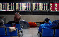 Investor melihat layar yang menampilkan informasi saham di sebuah rumah pialang di Shanghai, China