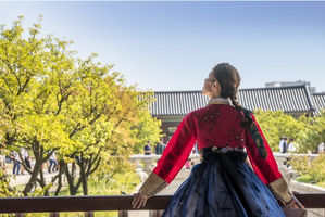 Wanita berbusana tradisional korea memandang ke langit