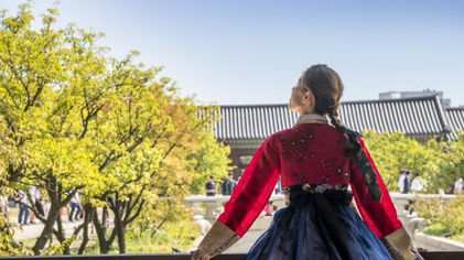 Wanita berbusana tradisional korea memandang ke langit