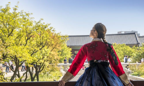 Wanita berbusana tradisional korea memandang ke langit