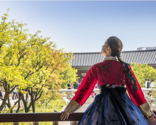 Wanita berbusana tradisional korea memandang ke langit