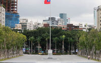 Seseorang berjalan di samping bendera Taiwan yang berkibar di luar Balai Peringatan Sun Yat-Sen di Taipei