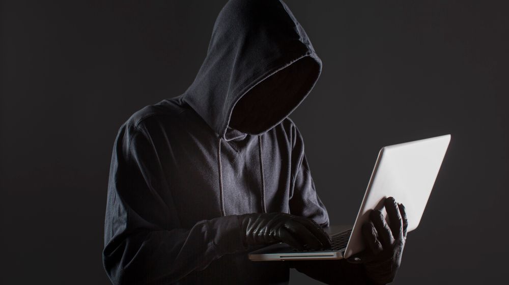 side-view-male-hacker-with-gloves-laptop.jpg
