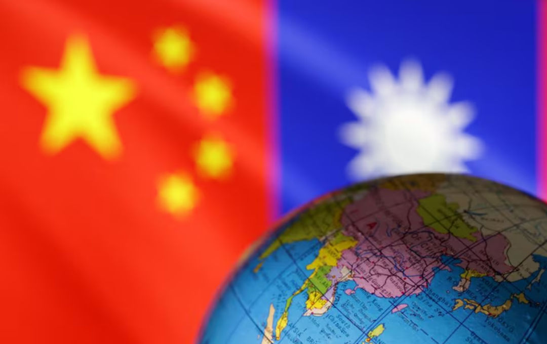 Sebuah bola dunia terlihat di depan bendera China dan Taiwan dalam ilustrasi