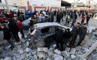Warga Palestina berkumpul di samping kendaraan yang rusak saat mereka memeriksa lokasi serangan Israel