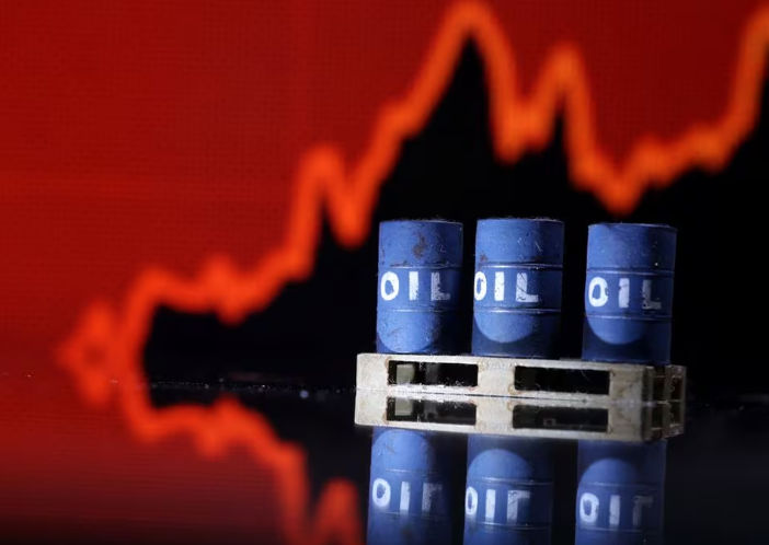Model barel minyak terlihat di depan grafik kenaikan stok pada ilustrasi (Reuters/Dado Ruvic)