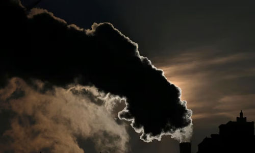 Asap dari cerobong asap membayang-bayangi matahari terbit di kota utara Harbin, provinsi Heilongjiang