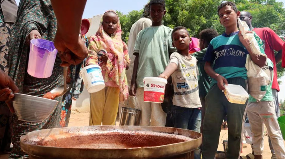 Orang-orang memegang panci saat relawan membagikan makanan di Omdurman, Sudan
