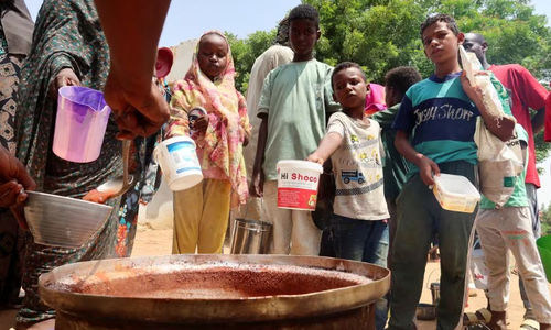 Orang-orang memegang panci saat relawan membagikan makanan di Omdurman, Sudan (Reuters/El Tayeb Siddig)