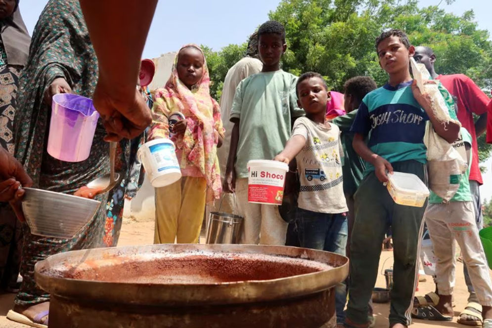 Orang-orang memegang panci saat relawan membagikan makanan di Omdurman, Sudan