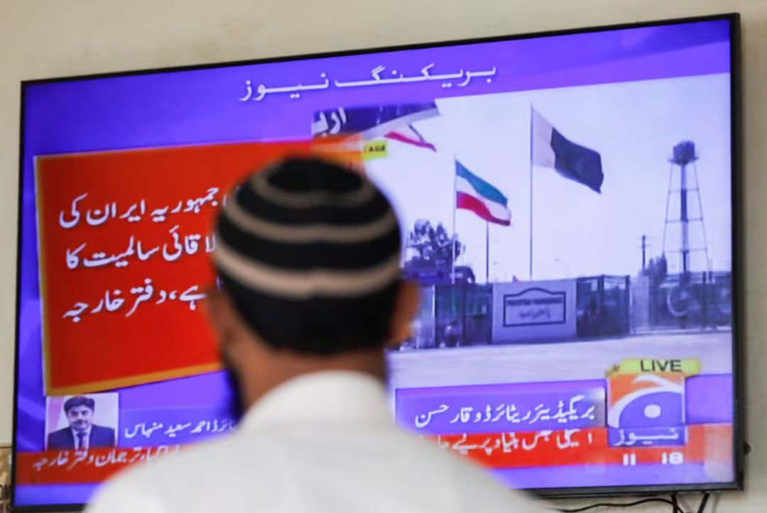 Seorang pria melihat layar televisi setelah kementerian luar negeri Pakistan mengatakan negara itu melakukan serangan di dalam Iran (Reuters/Akhtar Soomro)