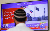 Seorang pria melihat layar televisi setelah kementerian luar negeri Pakistan mengatakan negara itu melakukan serangan di dalam Iran (Reuters/Akhtar Soomro)