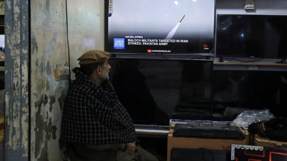 Seorang pria menonton saluran berita di televisi di dalam sebuah toko setelah kementerian luar negeri Pakistan mengatakan negara itu melakukan serangan di dalam Iran yang menargetkan militan separatis