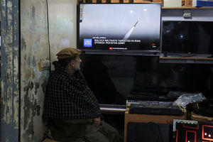 Seorang pria menonton saluran berita di televisi di dalam sebuah toko setelah kementerian luar negeri Pakistan mengatakan negara itu melakukan serangan di dalam Iran yang menargetkan militan separatis