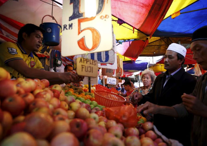 Orang-orang membeli buah-buahan di sebuah pasar di Kuala Lumpur, Malaysia (Reuters/Olivia Harris)