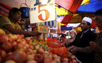 Orang-orang membeli buah-buahan di sebuah pasar di Kuala Lumpur, Malaysia