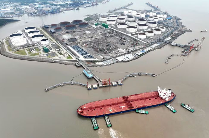 Pemandangan udara menunjukkan kapal tunda membantu kapal tanker minyak mentah berlabuh di terminal minyak, di lepas Pulau Waidiao di Zhoushan, provinsi Zhejiang, China (Reuters/cnsphoto)