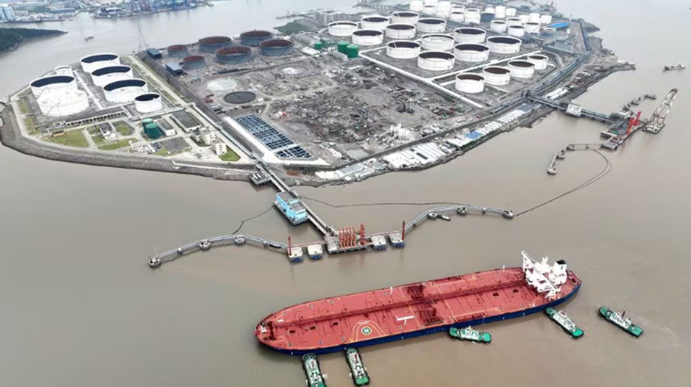 Pemandangan udara menunjukkan kapal tunda membantu kapal tanker minyak mentah berlabuh di terminal minyak, di lepas Pulau Waidiao di Zhoushan, provinsi Zhejiang, China