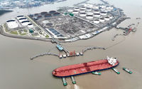 Pemandangan udara menunjukkan kapal tunda membantu kapal tanker minyak mentah berlabuh di terminal minyak, di lepas Pulau Waidiao di Zhoushan, provinsi Zhejiang, China