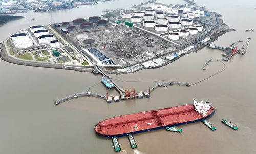 Pemandangan udara menunjukkan kapal tunda membantu kapal tanker minyak mentah berlabuh di terminal minyak, di lepas Pulau Waidiao di Zhoushan, provinsi Zhejiang, China