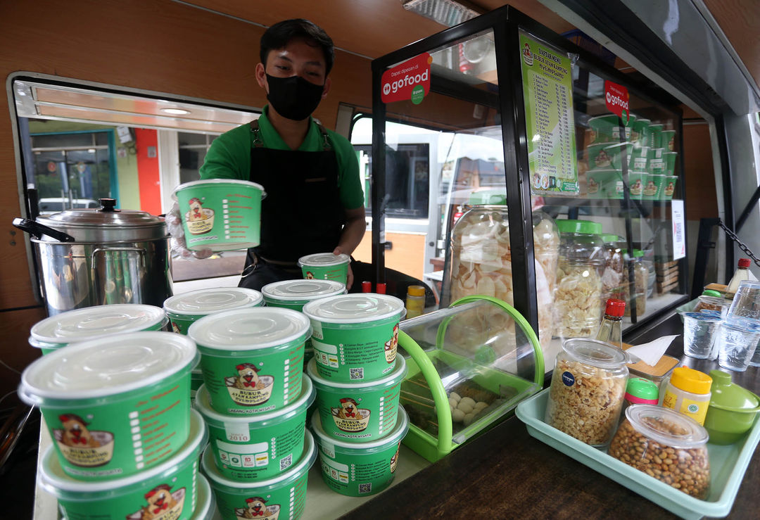 Nampak karyawan Bubur Ayam Kampung Nyemplung saat melayani pembeli di salah satu food truck yang berada di kawasan Ruko Gracia Recidence, Jl. Graha Raya Bintaro, Tangerang Selatan,Rabu 24 Januari 2024. Foto : Panji Asmoro/TrenAsia