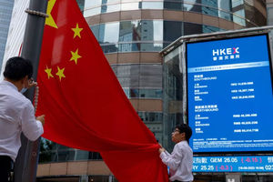 Staf menurunkan bendera nasional China di depan layar yang menampilkan indeks dan harga saham di luar Exchange Square, di Hong Kong, China