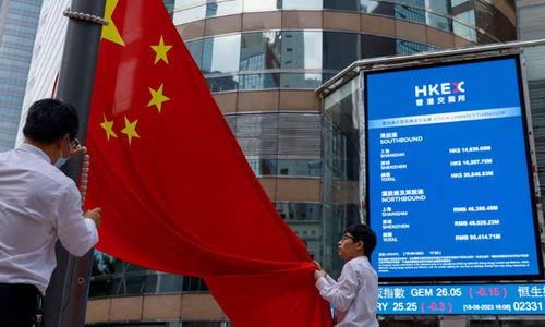 Staf menurunkan bendera nasional China di depan layar yang menampilkan indeks dan harga saham di luar Exchange Square, di Hong Kong, China