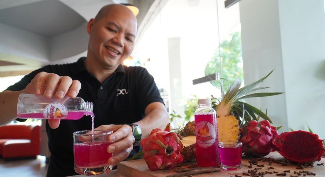 Hanjaya Siaputra, S.E., M.A., atau kerap disapa Tjun Han, dosen Hotel Management PCU (Petra Christian University) buat minuman fermentasi dari buah nanas dan buah naga yang rasanya seperti minuman anggur.