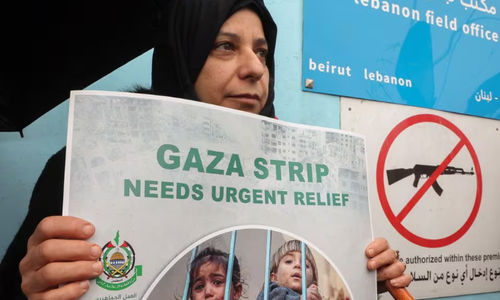 Seorang wanita Palestina memegang plakat saat protes menentang penangguhan dana UNRWA oleh beberapa negara Barat, di depan gedung badan bantuan Palestina PBB UNRWA di Beirut, Lebanon