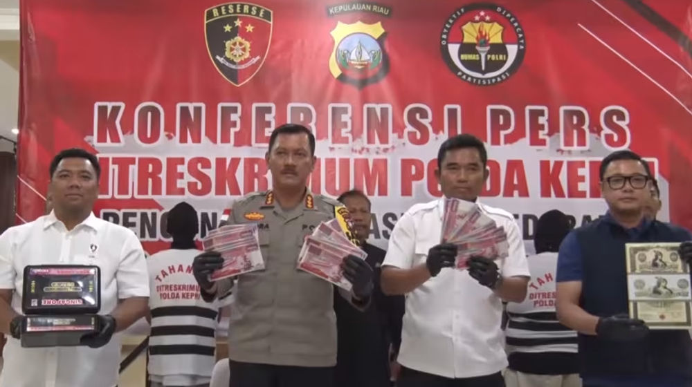  Petugas polisi Indonesia memegang uang kertas palsu setelah menangkap sindikat pada November 2023.