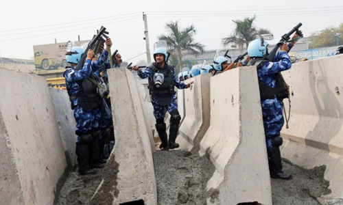 Petugas polisi mengangkat senjata saat barikade didirikan di jalan raya nasional untuk menghentikan para petani