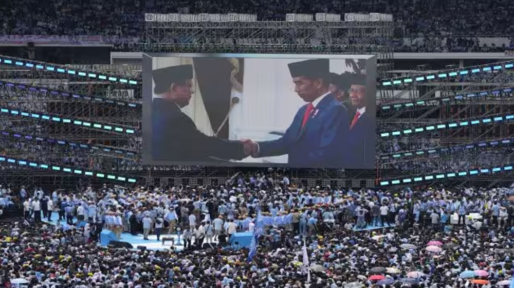 Presiden Indonesia Joko Widodo, berjabat tangan dengan calon presiden Prabowo Subianto ditampilkan di layar lebar saat kampanye kampanye Prabowo di Stadion Utama Gelora Bung Karno