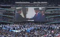 Presiden Indonesia Joko Widodo, berjabat tangan dengan calon presiden Prabowo Subianto ditampilkan di layar lebar saat kampanye kampanye Prabowo di Stadion Utama Gelora Bung Karno