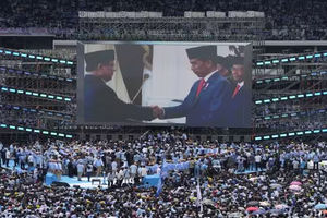 Presiden Indonesia Joko Widodo, berjabat tangan dengan calon presiden Prabowo Subianto ditampilkan di layar lebar saat kampanye kampanye Prabowo di Stadion Utama Gelora Bung Karno