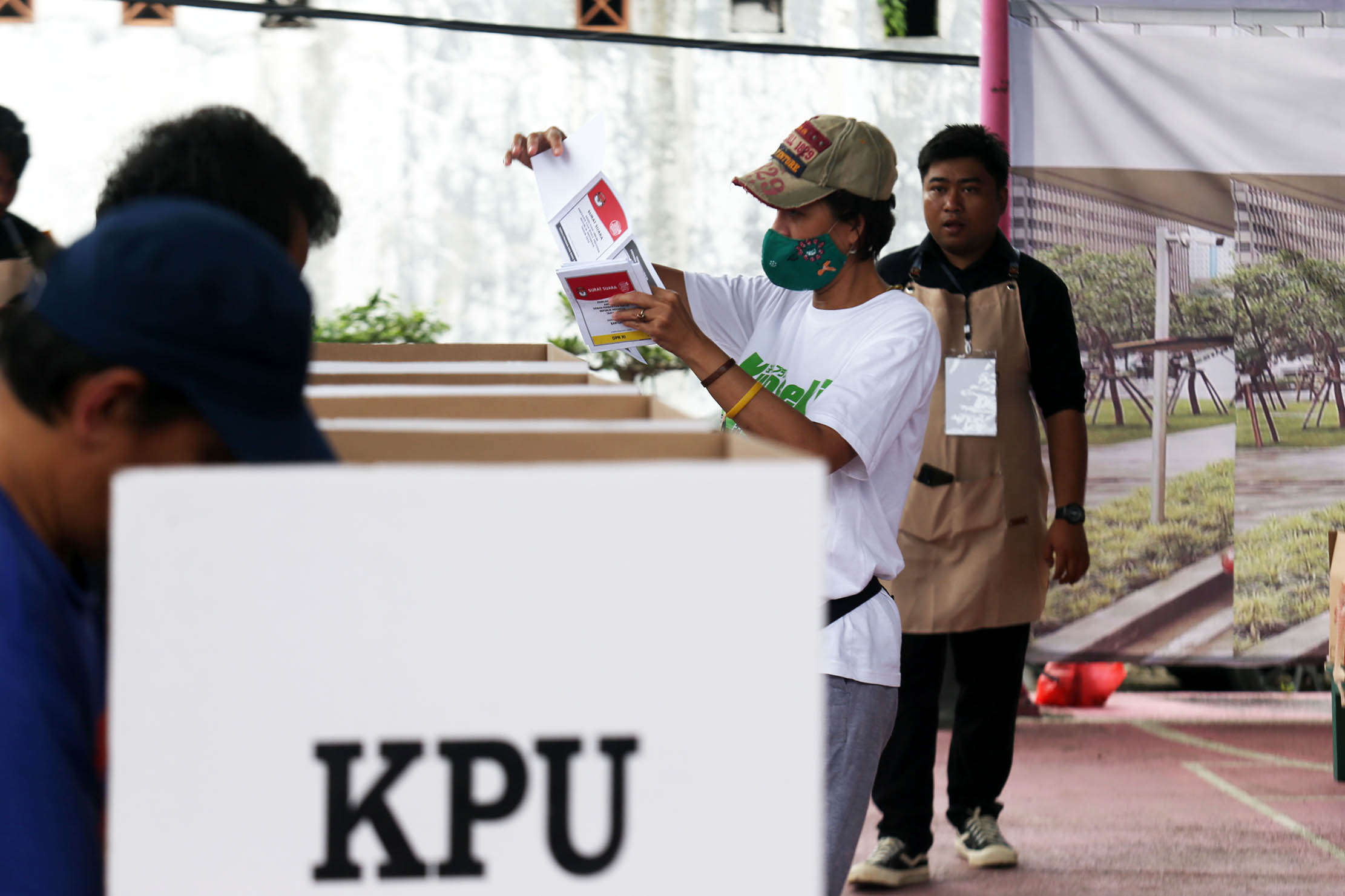 Petugas KPPS mengenakan ala barista mengawasi pencoblosan surat suara  di TPS 11 Cornelia Residence Pondok Jagung Tangerang Selatan, Rabu 14 Februari 2024. Foto : Panji Asmoro/TrenAsia