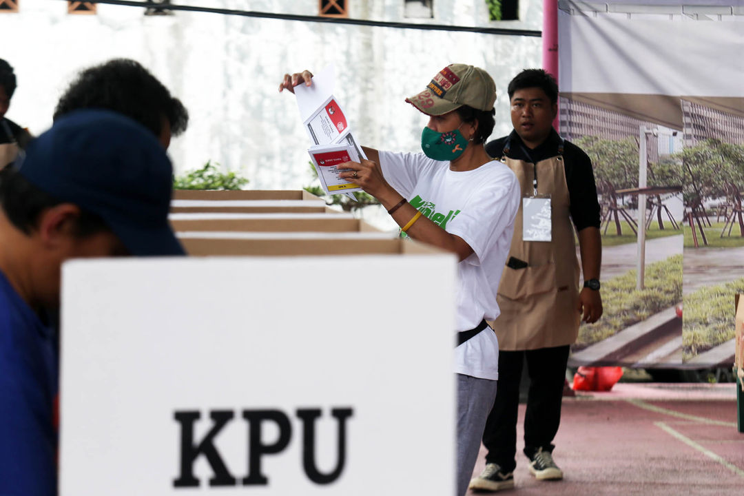 Petugas KPPS mengenakan ala barista mengawasi pencoblosan surat suara  di TPS 11 Cornelia Residence Pondok Jagung Tangerang Selatan, Rabu 14 Februari 2024. Foto : Panji Asmoro/TrenAsia