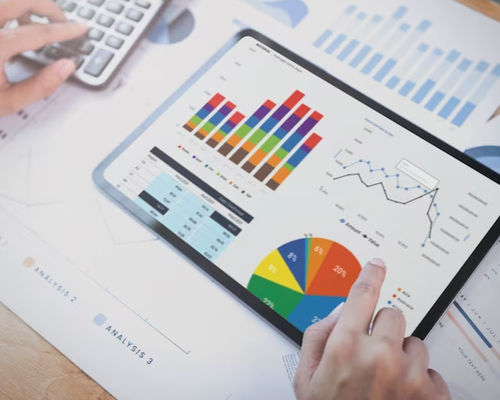 Foto seorang pebisnis menggunakan tablet untuk menganalisis grafik statistik strategi keuangan perusahaan.