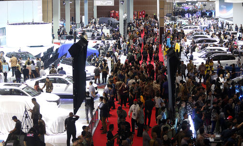 Pengunjung melihat mobil yang dipamerkan dalam Indonesian International Motor Show (IIMS) 2024 di JIExpo Kemayoran. Pameran otomotif IIMS 2024 yang berlangsung 15-25 Pebruari itu diikuti 53 merek kendaraan dan 187 peserta dari berbagai sektor dengan target transaksi mencapai Rp5,3 triliun. Foto : Panji Asmoro/TrenAsia