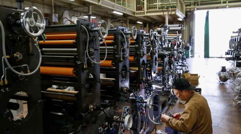 Seorang pekerja memeriksa mesin di sebuah pabrik di Higashiosaka, Jepang