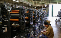 Seorang pekerja memeriksa mesin di sebuah pabrik di Higashiosaka, Jepang